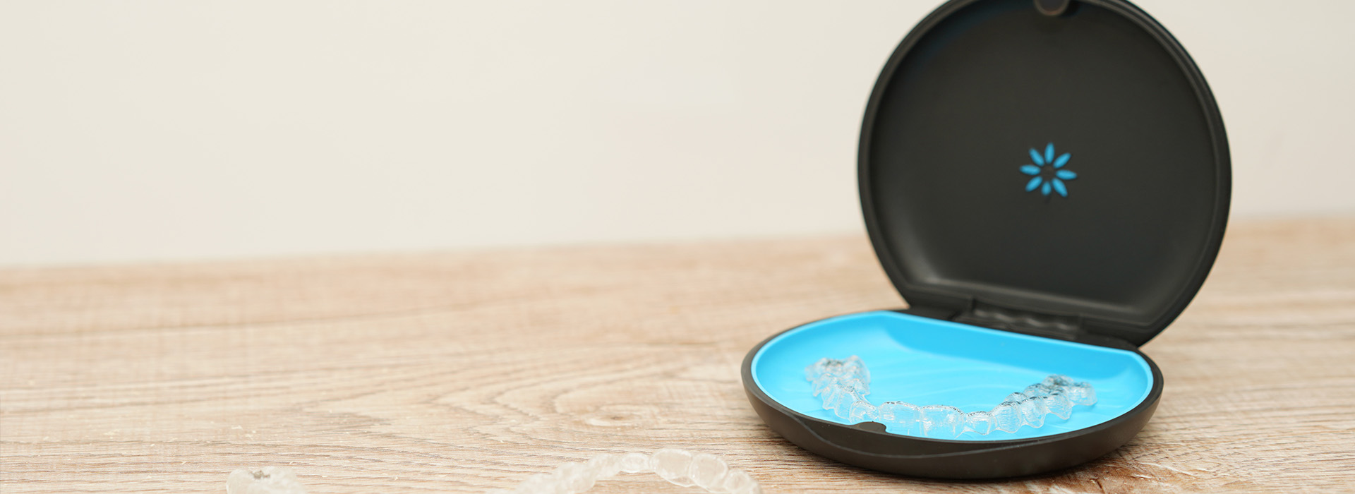 The image displays a black smart air purifier with a blue circular design on its top side, placed against a plain background.