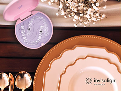 The image shows a collection of tableware including plates, bowls, and a spoon rest, displayed on a wooden surface with a pink-toned object resembling a toothbrush holder nearby.