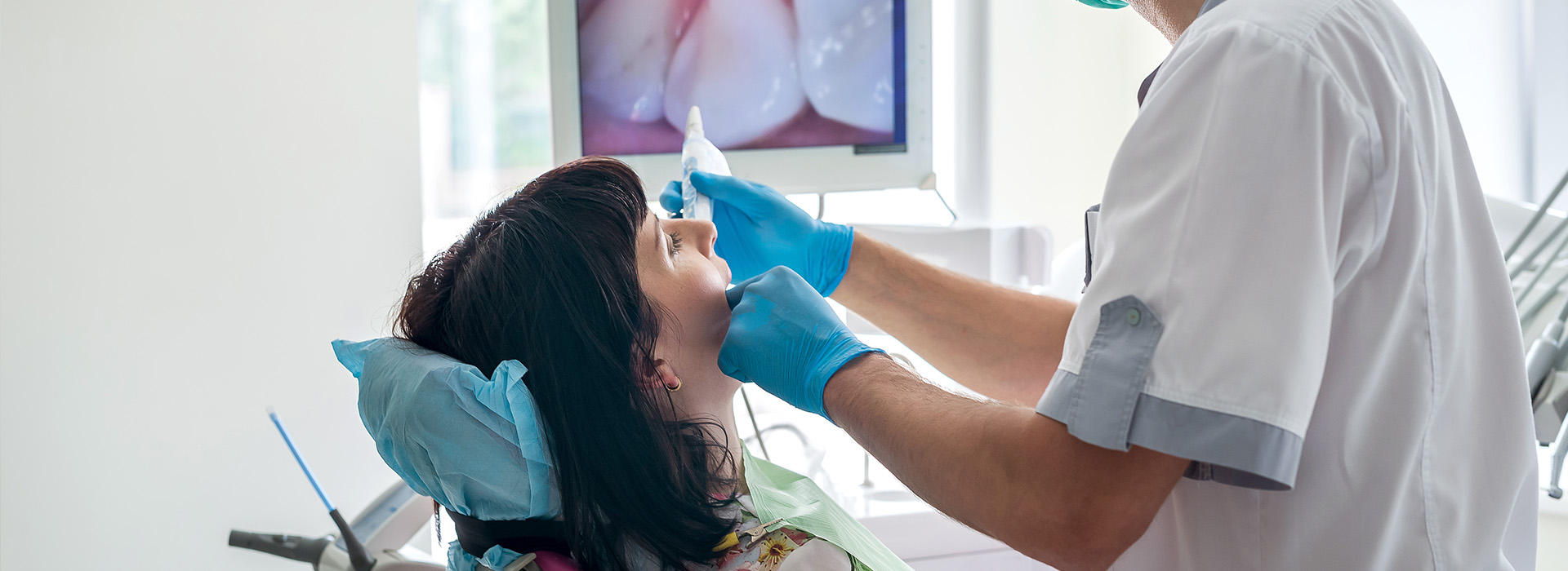 A dental professional performing oral care on a patient in a clinical setting.