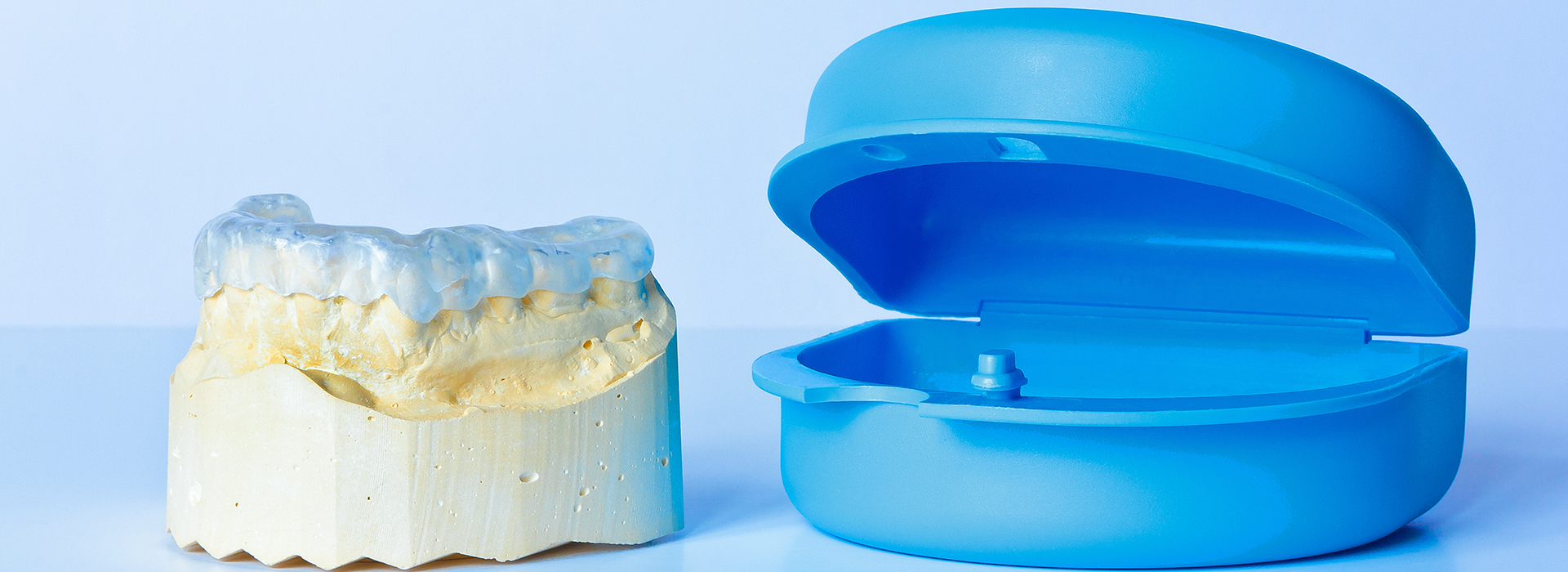 An image showcasing dental implants with a blue resin model alongside a real implant.