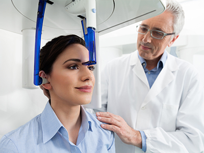 A medical professional assisting a patient with a head scanner.